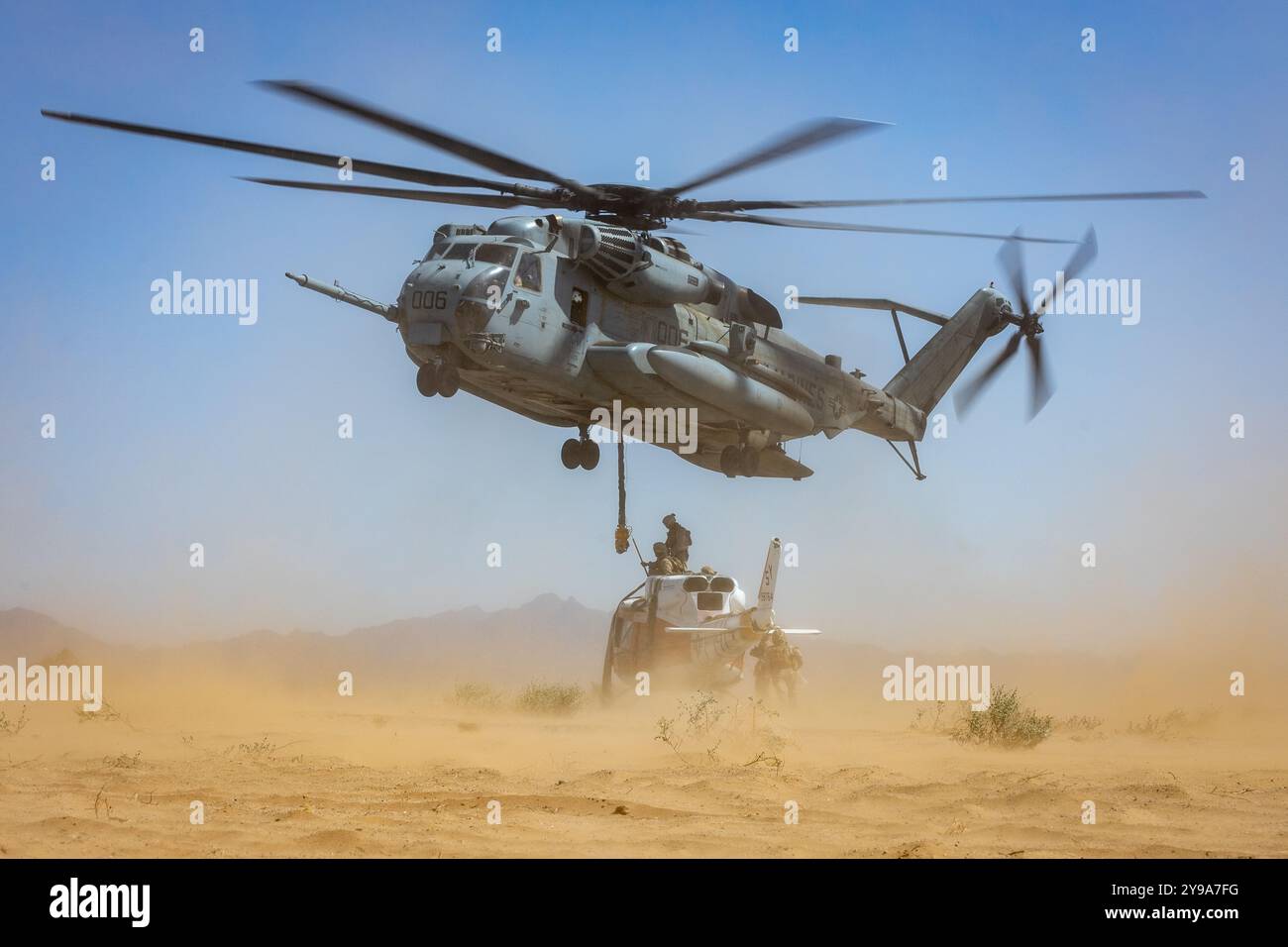 U.S. Marines observe a CH53E Super Stallion maneuvering while lifting