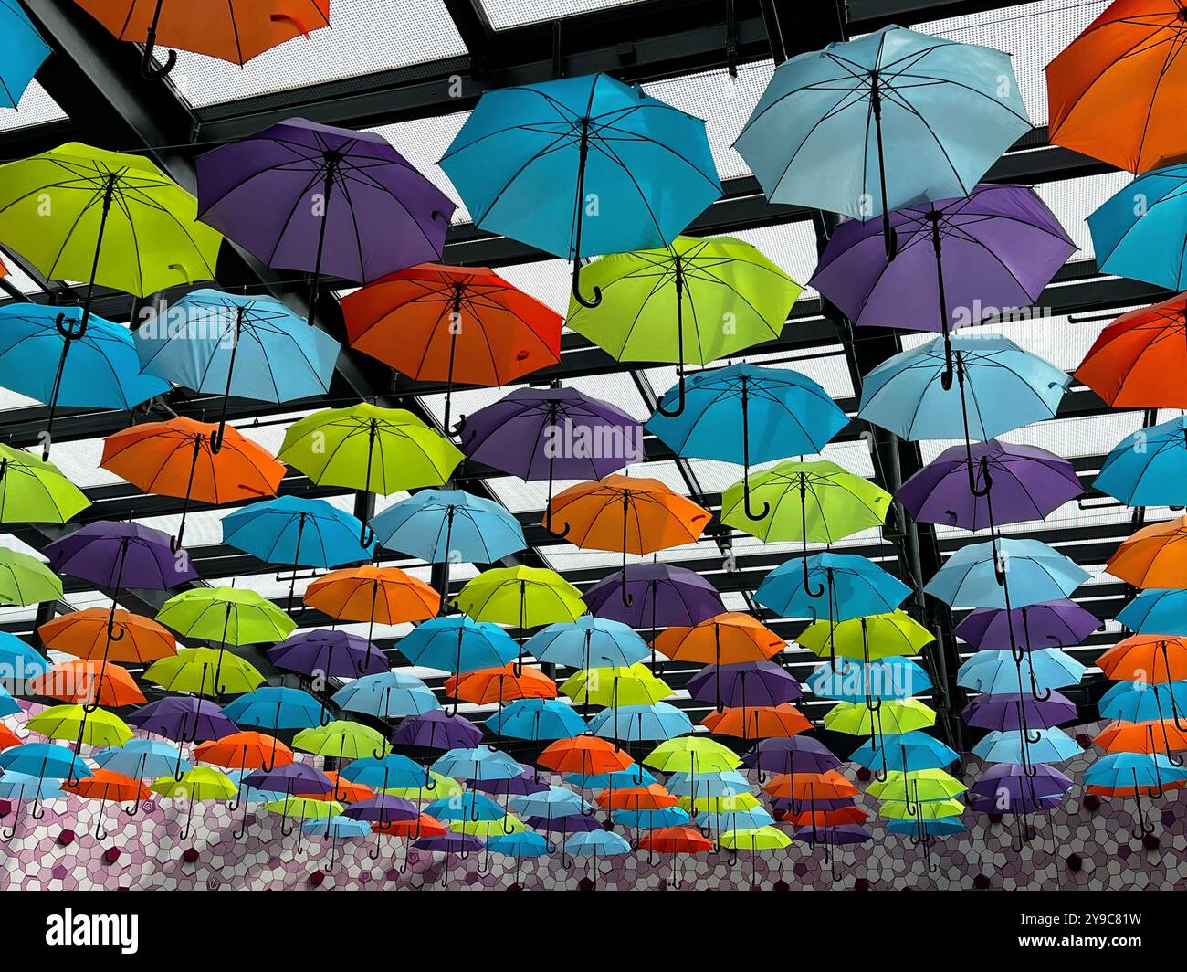 Beautiful colorful installayion with open umbrellas in lines against glass ceiling roof in the shopping mall of Split, Croatia - Smartphone Captured Stock Image