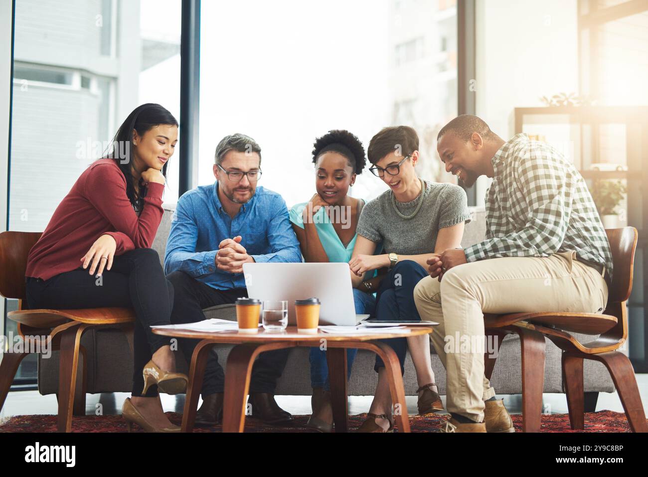 Office, meeting and people with laptop at table for project information, review and IT research. Company, diversity and developer team with tech for Stock Photo