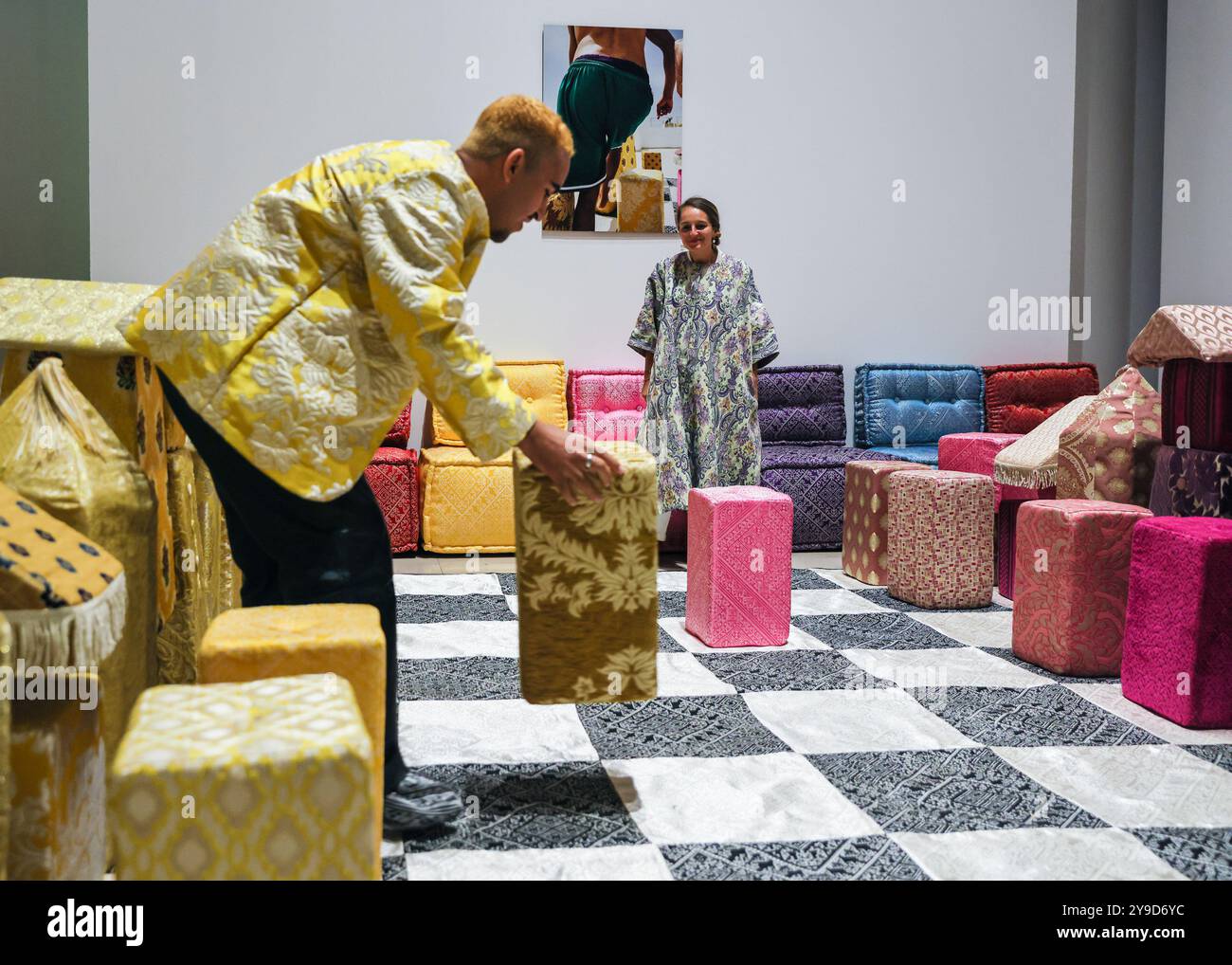 London, UK. 10th Oct 2024. Artist Sophia Kacimi, and photographer Osama (who created the integral imagery featured in the work) with the installation. The colourful centrepiece installation 'Play on Craft' by Sophia Kacimi and artisan friends, part of the Zoubida Project. The instsallation is a playful take inspired by Moroccan fabrics and everyday life, visitors are encourraged to interact with the giant chess board game. 1-54 Contemporary African Art Fair celebrates its 12th Edition at Somerset House with the special installation. Over 60 galleries and 160 artists from Africa and the diaspor Stock Photo