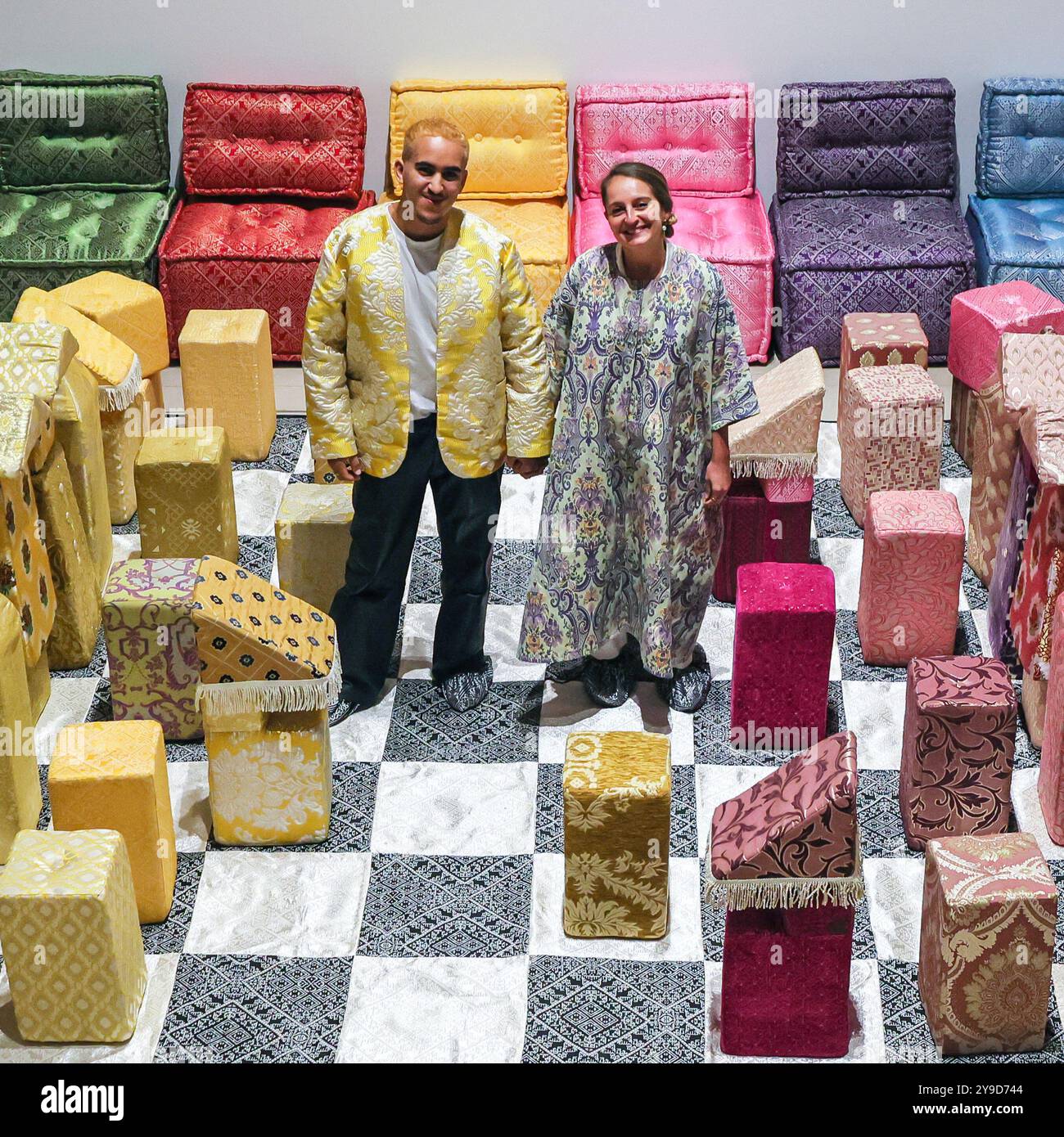 London, UK. 10th Oct 2024. Artist Sophia Kacimi, and photographer Osama (who created the integral imagery featured in the work) with the installation. The colourful centrepiece installation 'Play on Craft' by Sophia Kacimi and artisan friends, part of the Zoubida Project. The instsallation is a playful take inspired by Moroccan fabrics and everyday life, visitors are encourraged to interact with the giant chess board game. 1-54 Contemporary African Art Fair celebrates its 12th Edition at Somerset House with the special installation. Over 60 galleries and 160 artists from Africa and the diaspor Stock Photo