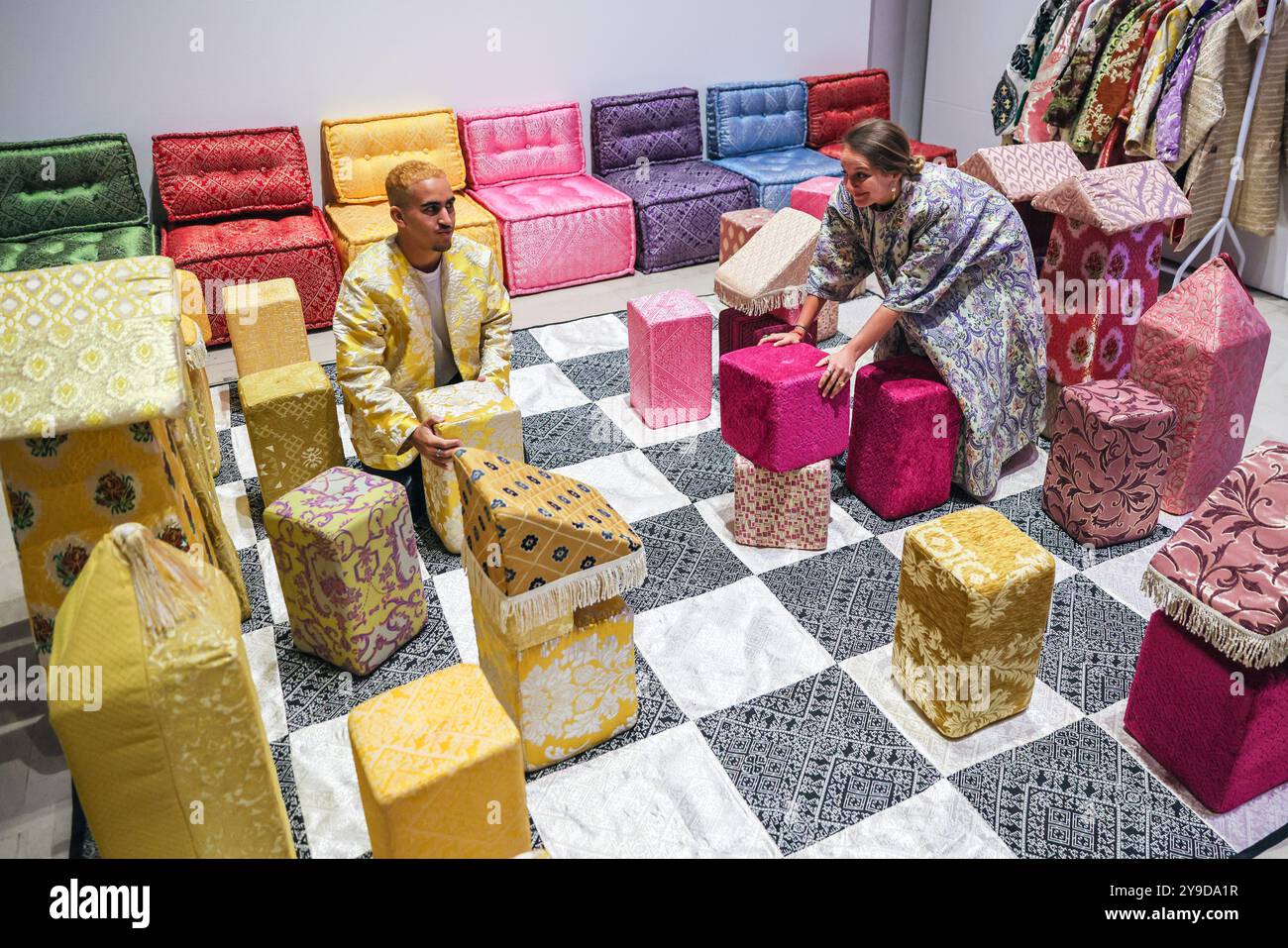 London, UK. 10th Oct 2024. Artist Sophia Kacimi, and photographer Osama (who created the integral imagery featured in the work) with the installation. The colourful centrepiece installation 'Play on Craft' by Sophia Kacimi and artisan friends, part of the Zoubida Project. The instsallation is a playful take inspired by Moroccan fabrics and everyday life, visitors are encourraged to interact with the giant chess board game. 1-54 Contemporary African Art Fair celebrates its 12th Edition at Somerset House with the special installation. Over 60 galleries and 160 artists from Africa and the diaspor Stock Photo