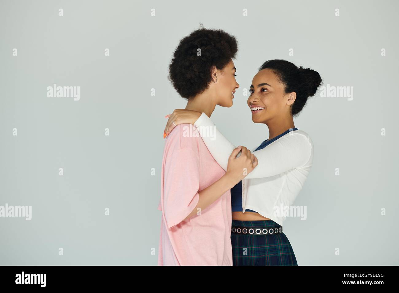 Two young women share a heartfelt embrace, radiating happiness and ...