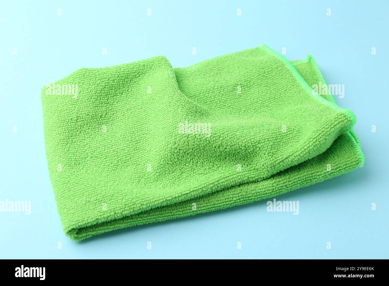 Clean green microfiber cloth on light blue background, closeup Stock Photo