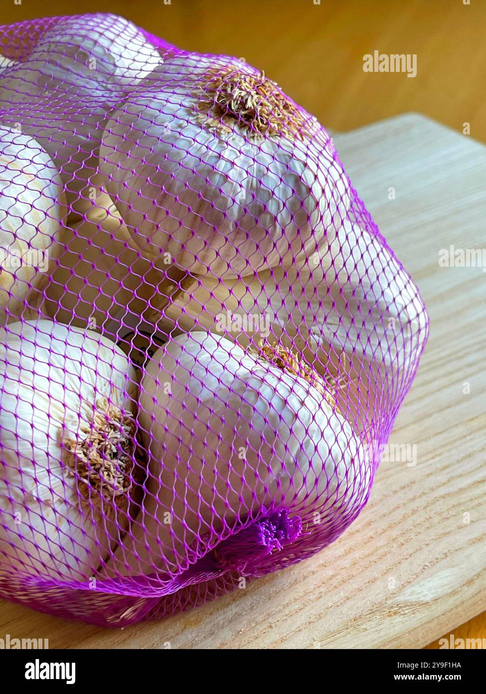 Garlics in plastic net. Still life. - Smartphone Captured Stock Image