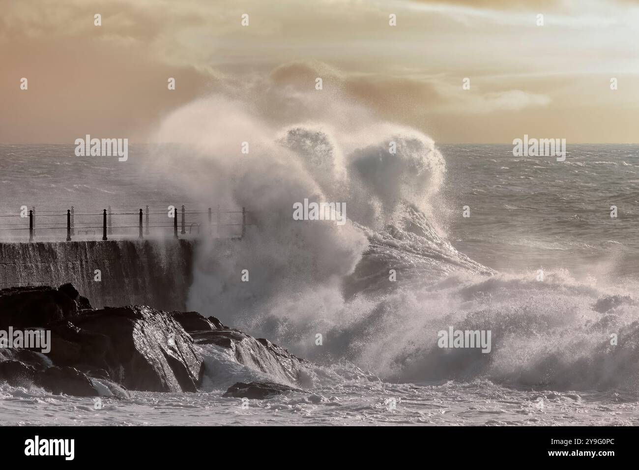 Big stormy sea wave splash against pier at sunset Stock Photo - Alamy