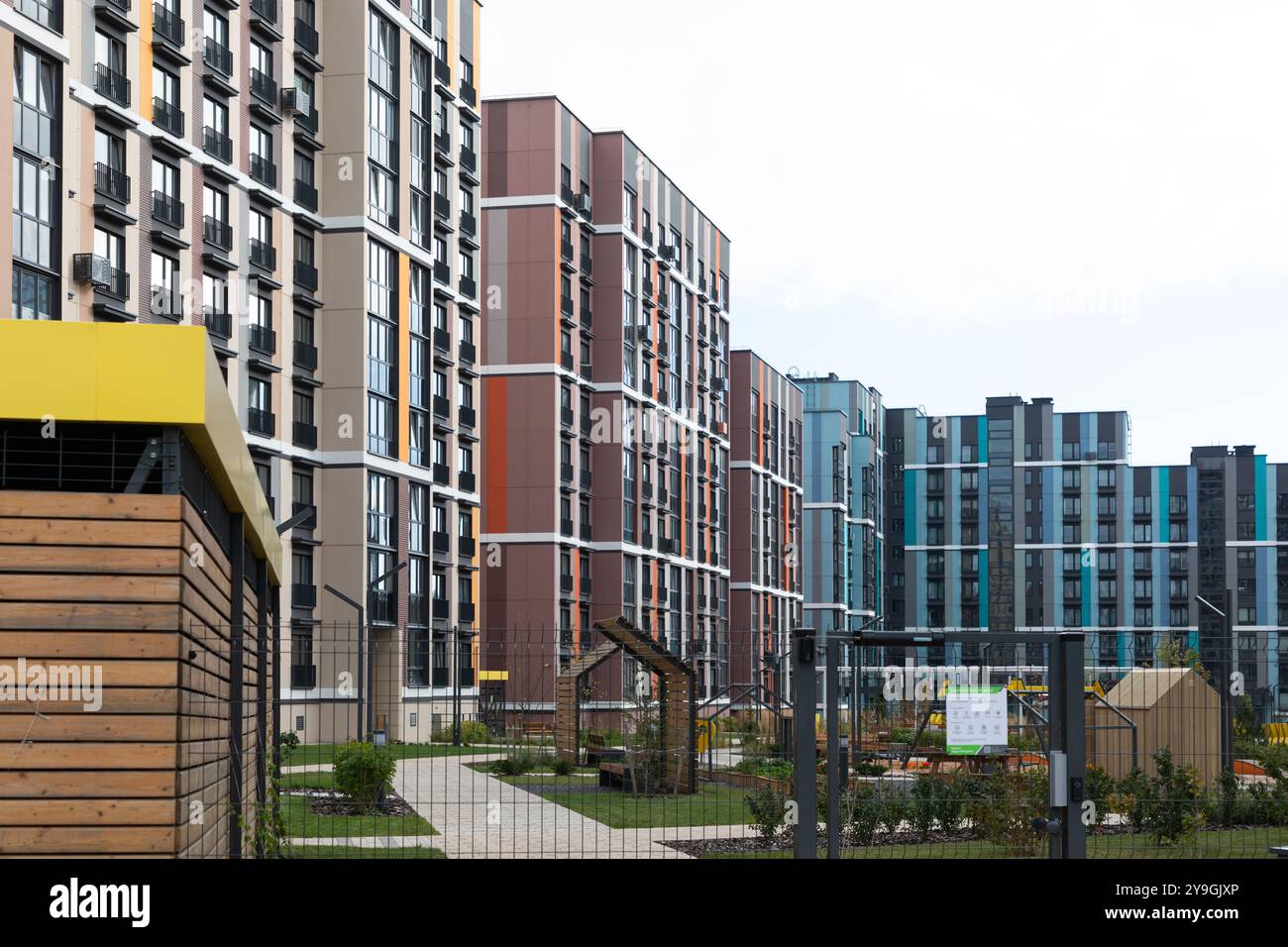 Image showcasing A modern residential area with high-rise apartment buildings and green ...