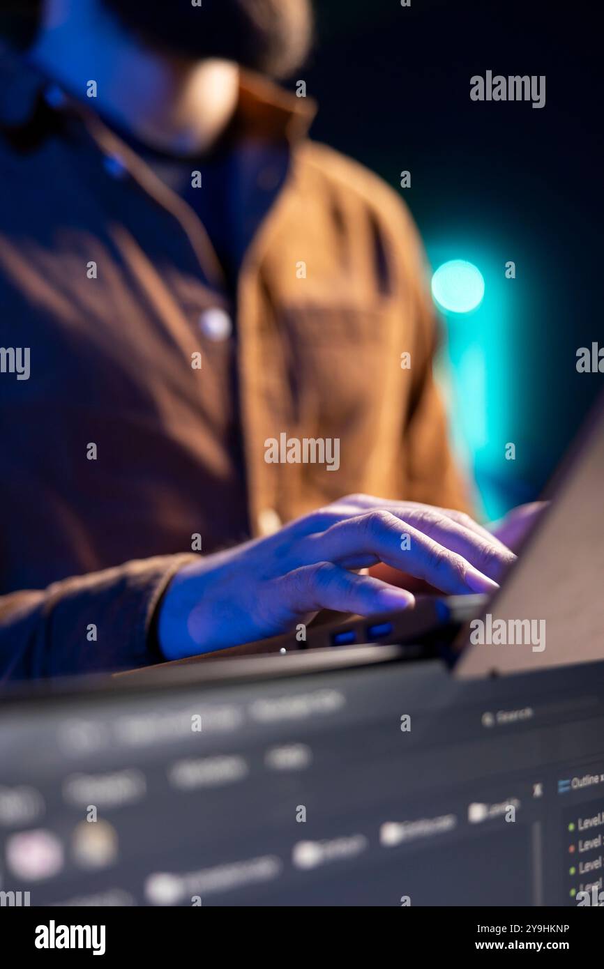 Teleworking programmer doing software debugging using laptop, checking flaws in lines of code displayed on PC monitors. IT admin in apartment fixing coding issues using notebook, close up Stock Photo