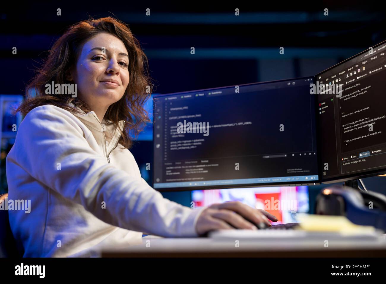 Portrait of smiling IT professional working from home developing software in Java programming language using desktop PC. Joyous developer in apartment writing lines of binary code on computer Stock Photo