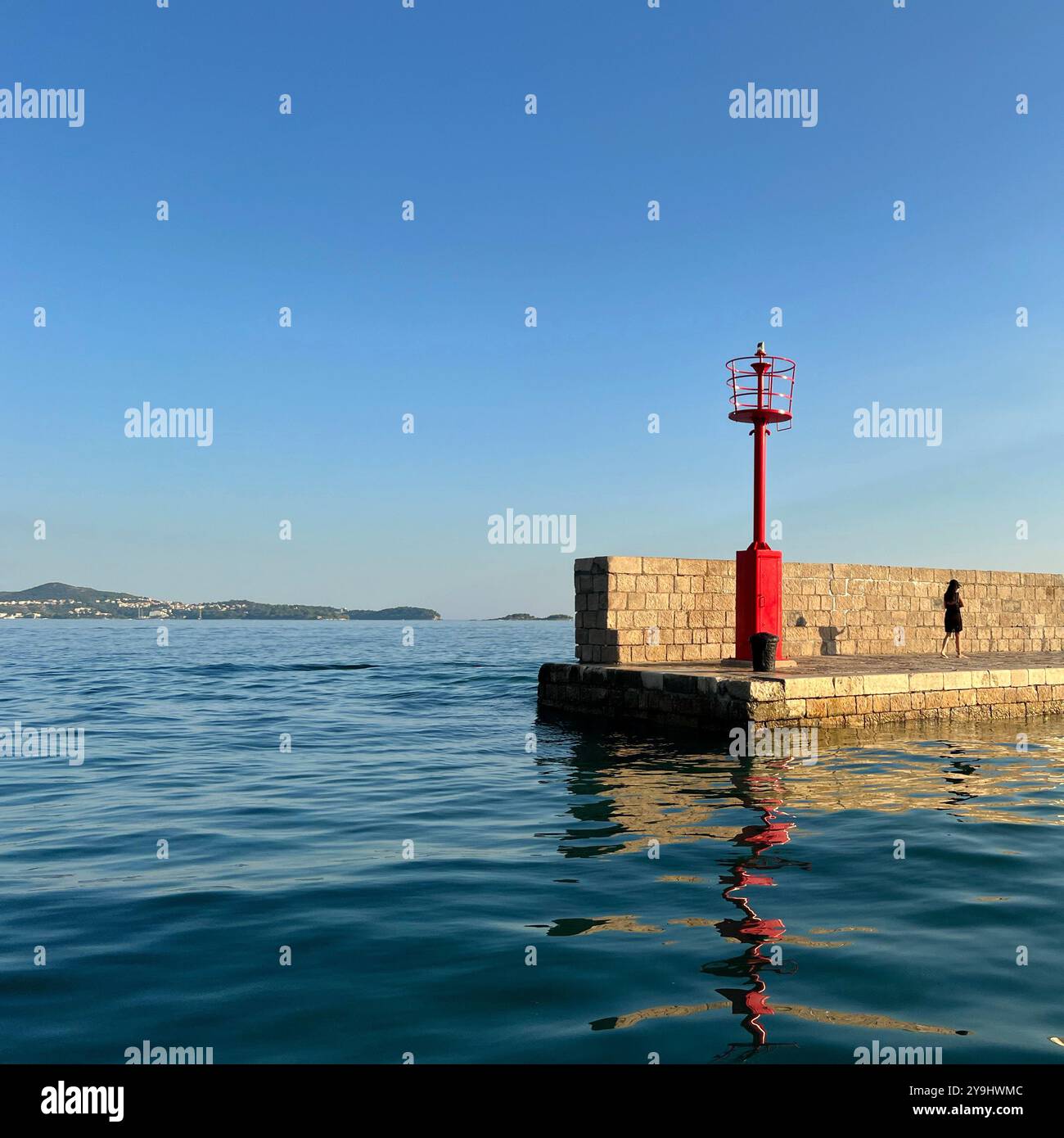 Figure walking along Harbour wall at Srebreno near Dubrovnik, Croatia - Smartphone Captured Stock Image