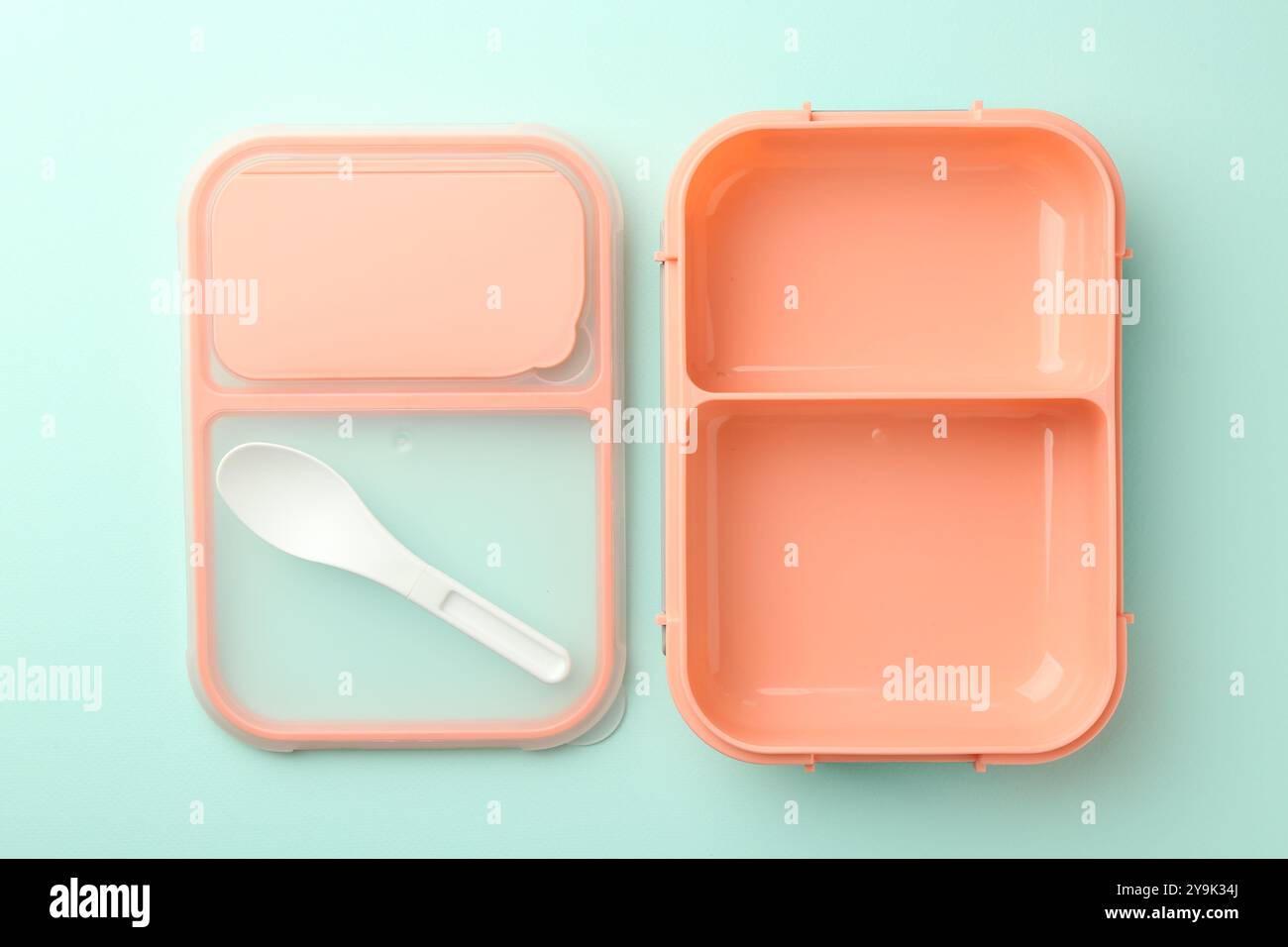 Empty lunch box with spoon on light blue background, flat lay Stock Photo