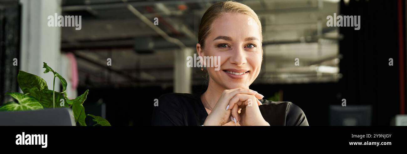 A young, confident plus size woman smiles warmly at her office desk ...