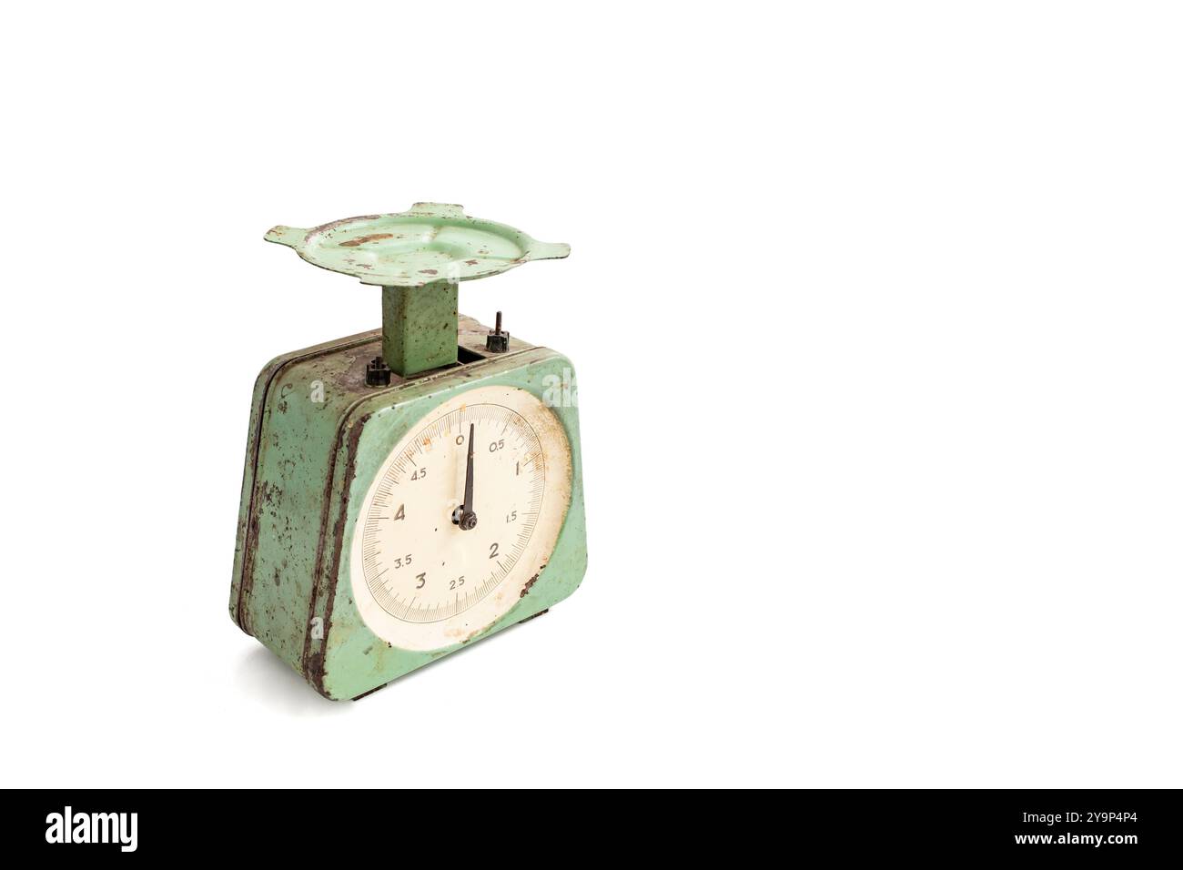 Obsolete vintage kitchen scale, with rust spots and green peeling paint, isolated on white Stock Photo