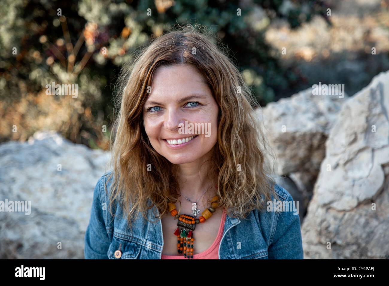 Portrait of beautiful woman with blue eyes against stones Stock Photo