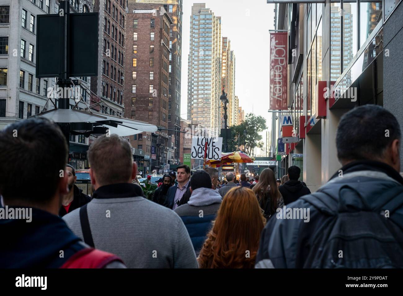 Crowded New York sidewalk Love Jesus sign Stock Photo