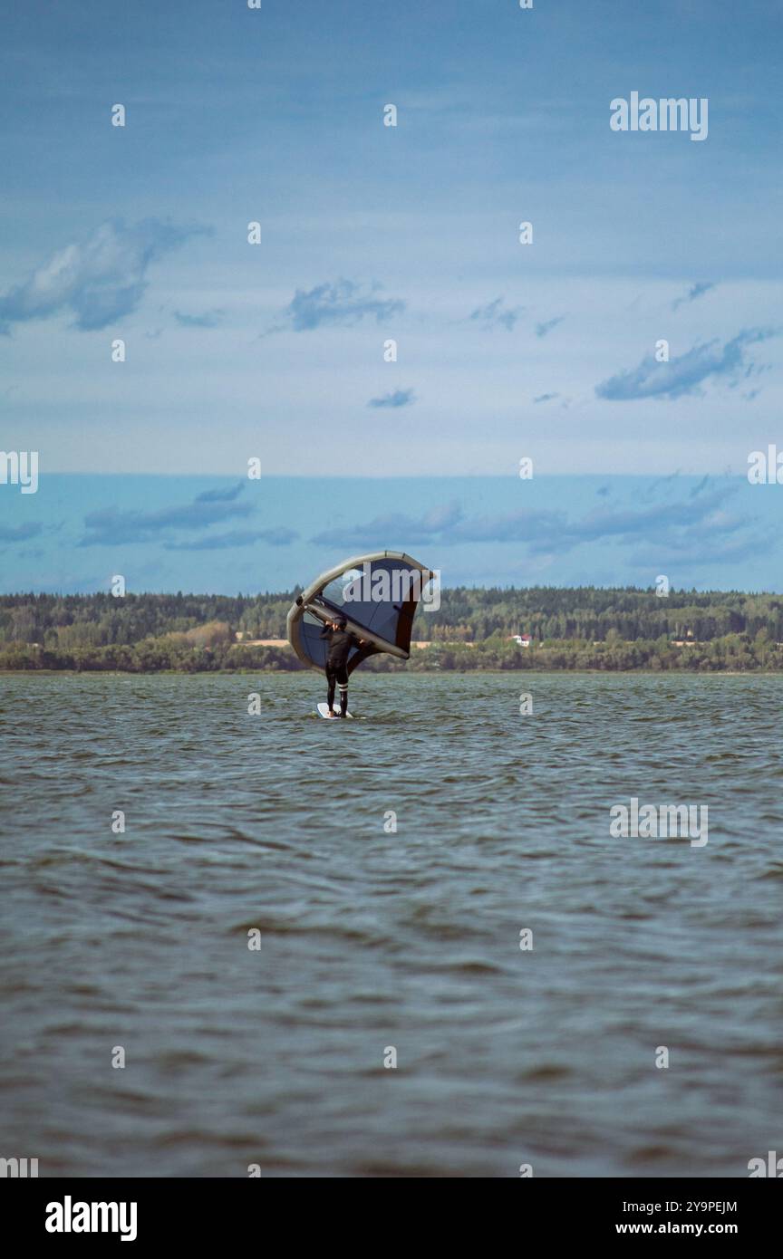Wing foil rider riding in the lake Stock Photo - Alamy