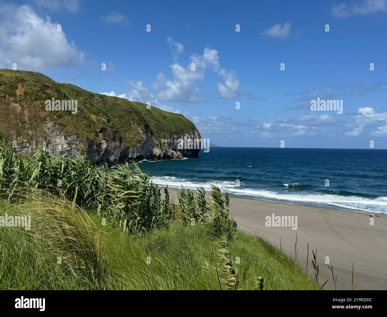 Scenic coastal view of a sandy beach and green cliffs at Ribeira Grande, São Miguel Island, Azores, Portugal. - Smartphone Captured Stock Image