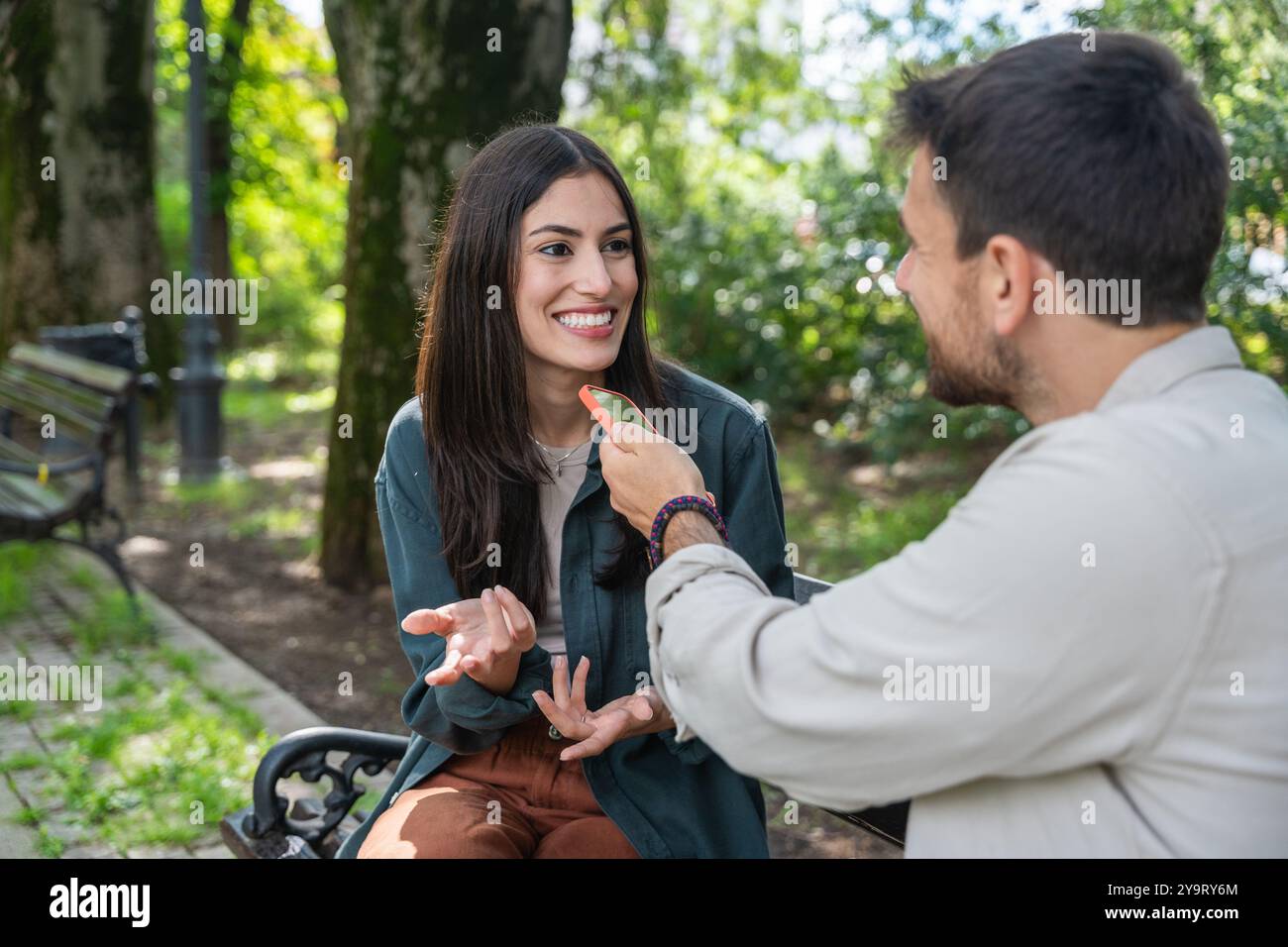 Street interviews. Young freelance independent journalist and vlogger interview random people on the street about their life. Man recording audio soun Stock Photo