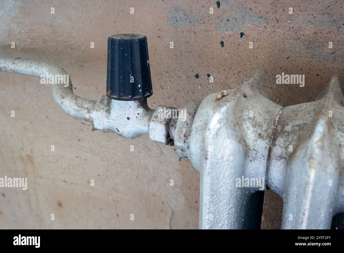 old vintage radiator with valve on the wall Stock Photo - Alamy