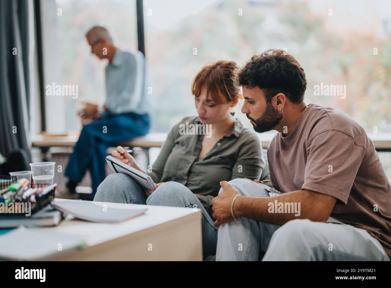 Engaged students collaborating in a modern classroom setting Stock Photo