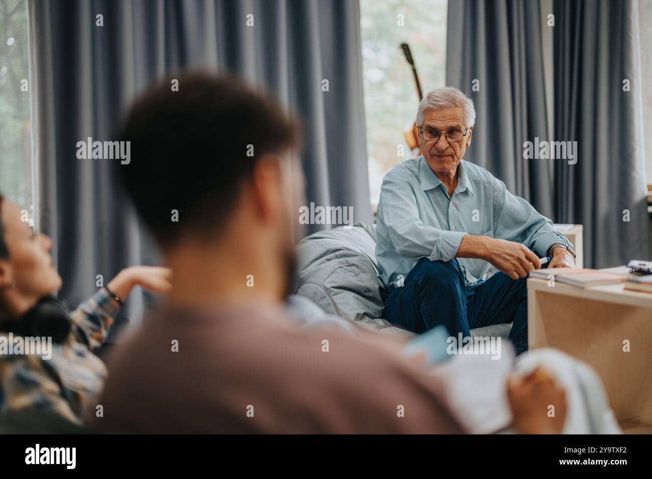 Professor engaging with students in casual setting discussion Stock Photo