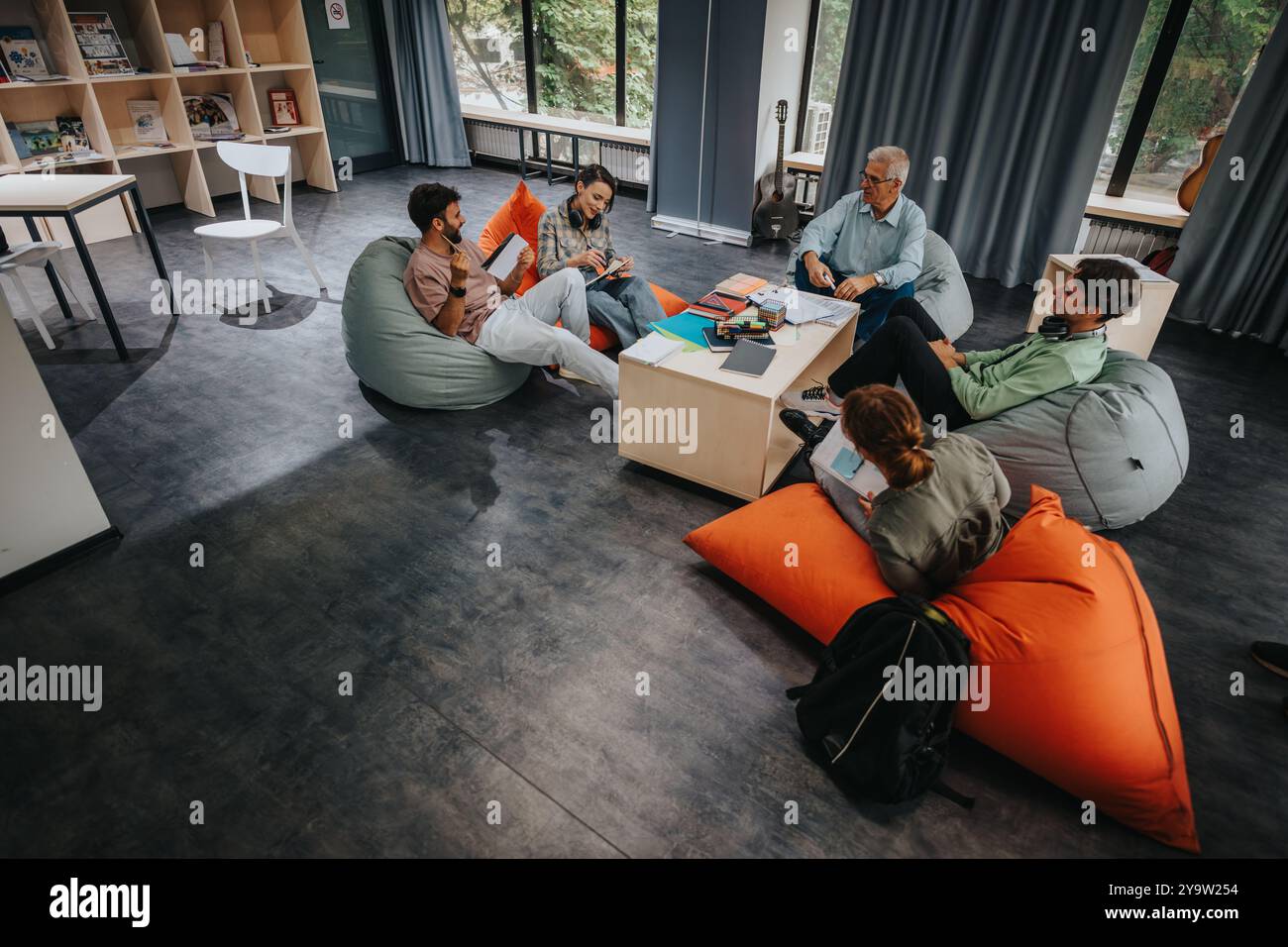 Professor engaging with students in a relaxed learning environment Stock Photo