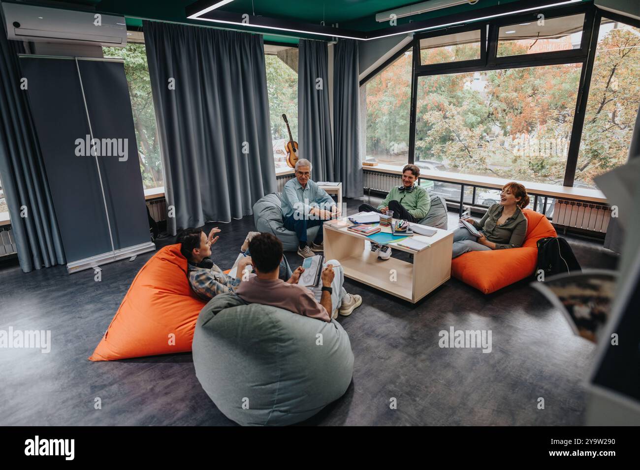 Professor engaging with students in modern study lounge Stock Photo