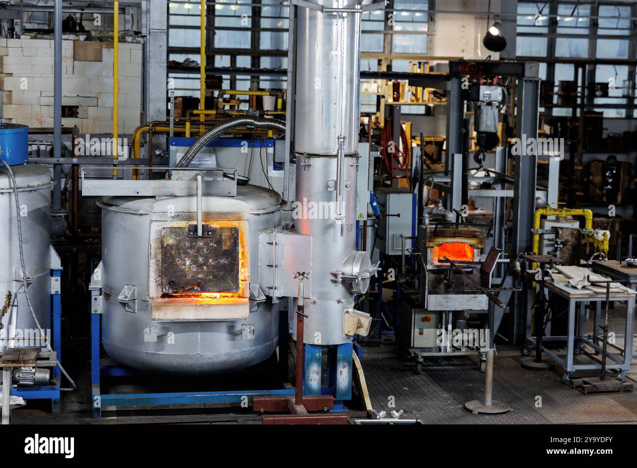 Industrial glassblowing furnaces actively running in glassware factory ...