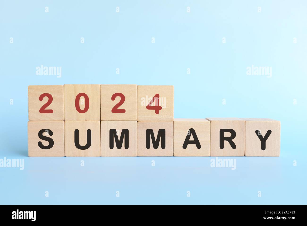 Year end 2024 summary concept. Wooden blocks typography in blue background. Stock Photo