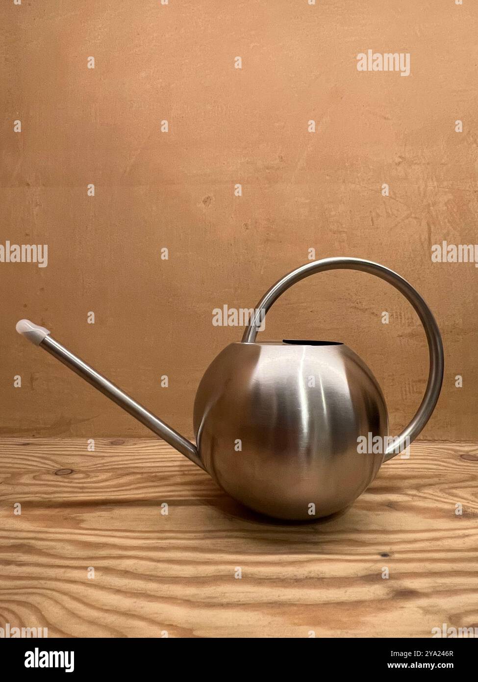 A silver round shape watering can, minimal design for your growing plant corner. The exterior gives a deluxe mood feel. - Smartphone Captured Stock Image