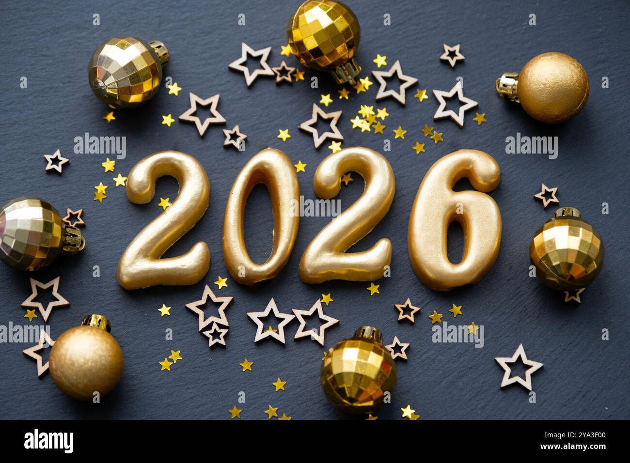 The golden figures 2026 made of candles on a black stone slate