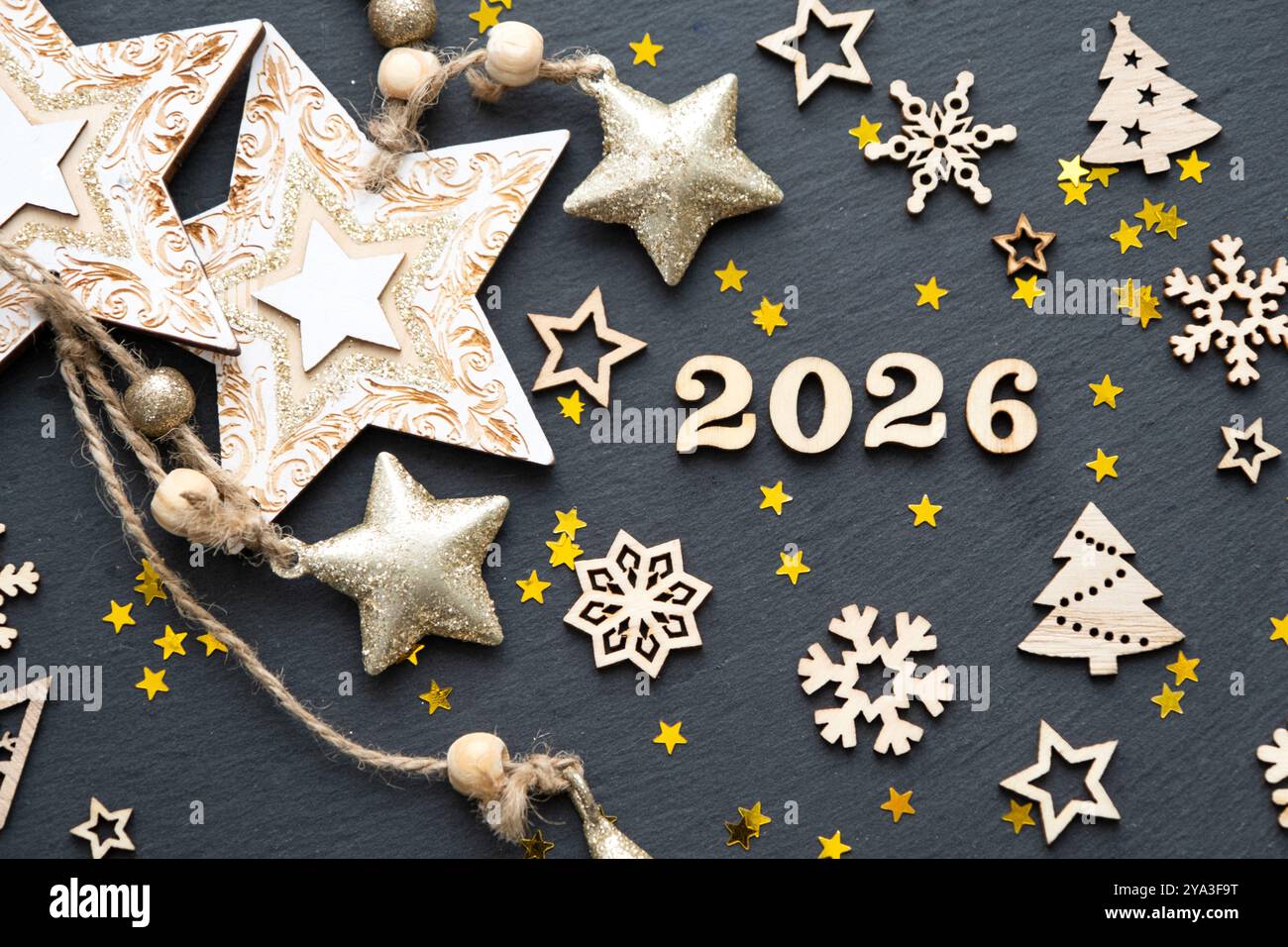Happy New Yearwooden letters and the numbers 2026 on festive black
