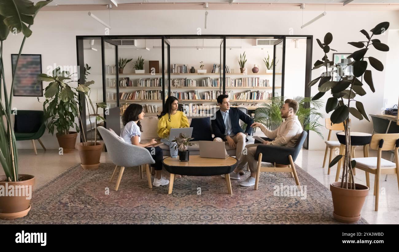 Diverse business team talking in modern co-working meeting space Stock Photo