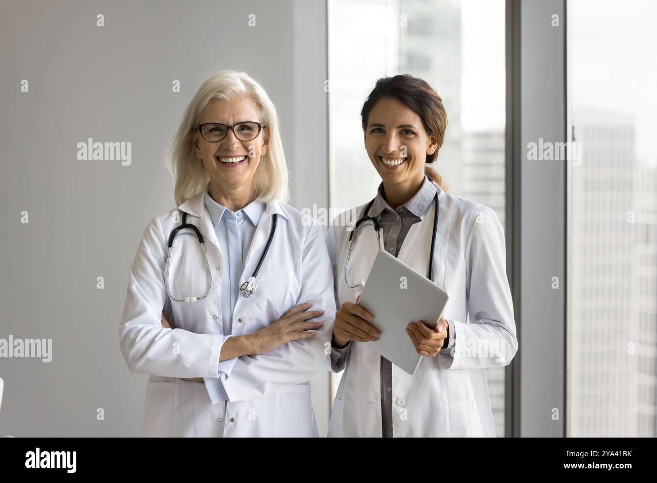 Two female doctors standing in white coats looking at camera Stock Photo