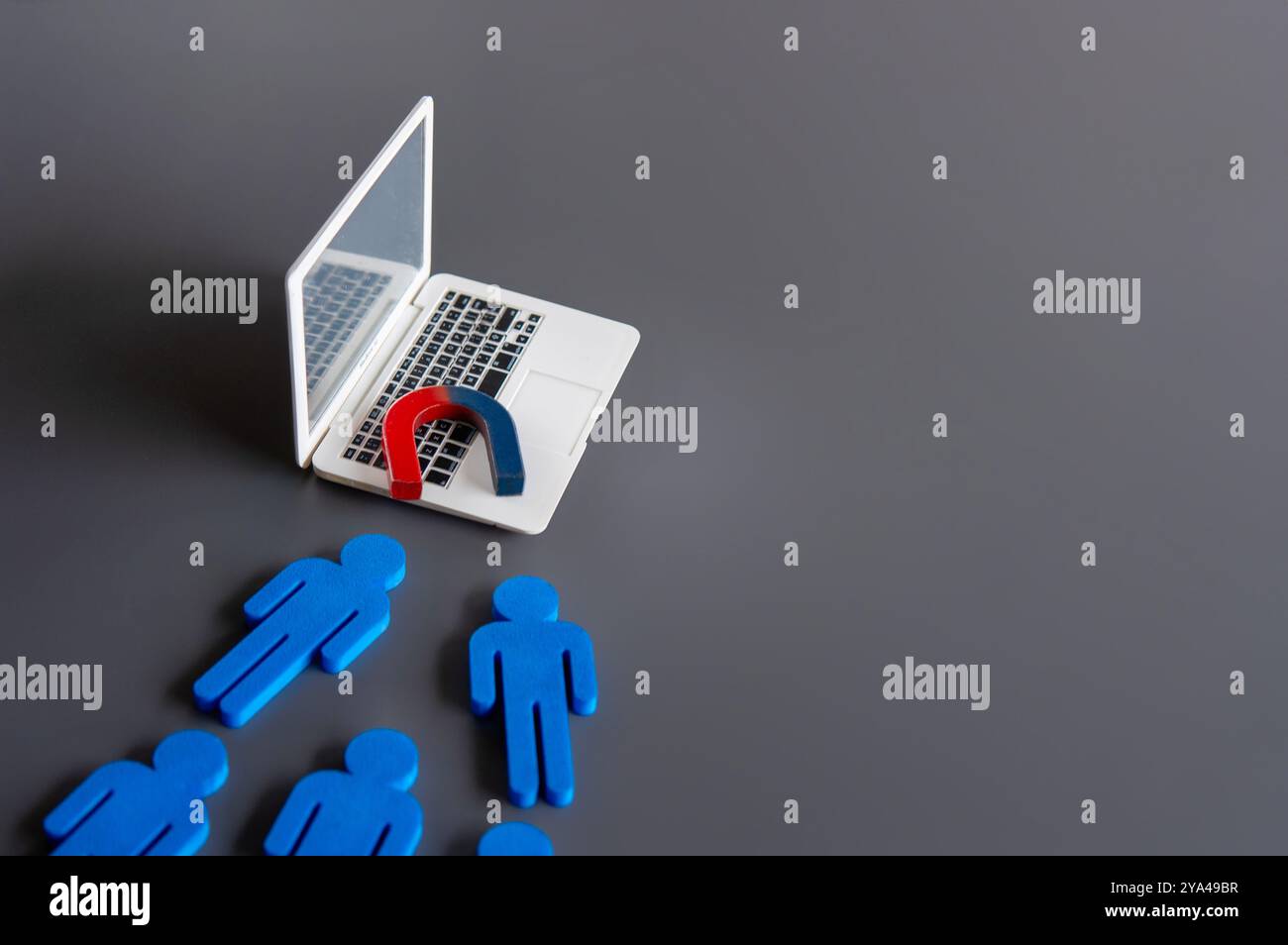 Magnet on top of a laptop attract customers. Online marketing and attracting customers concept. Stock Photo
