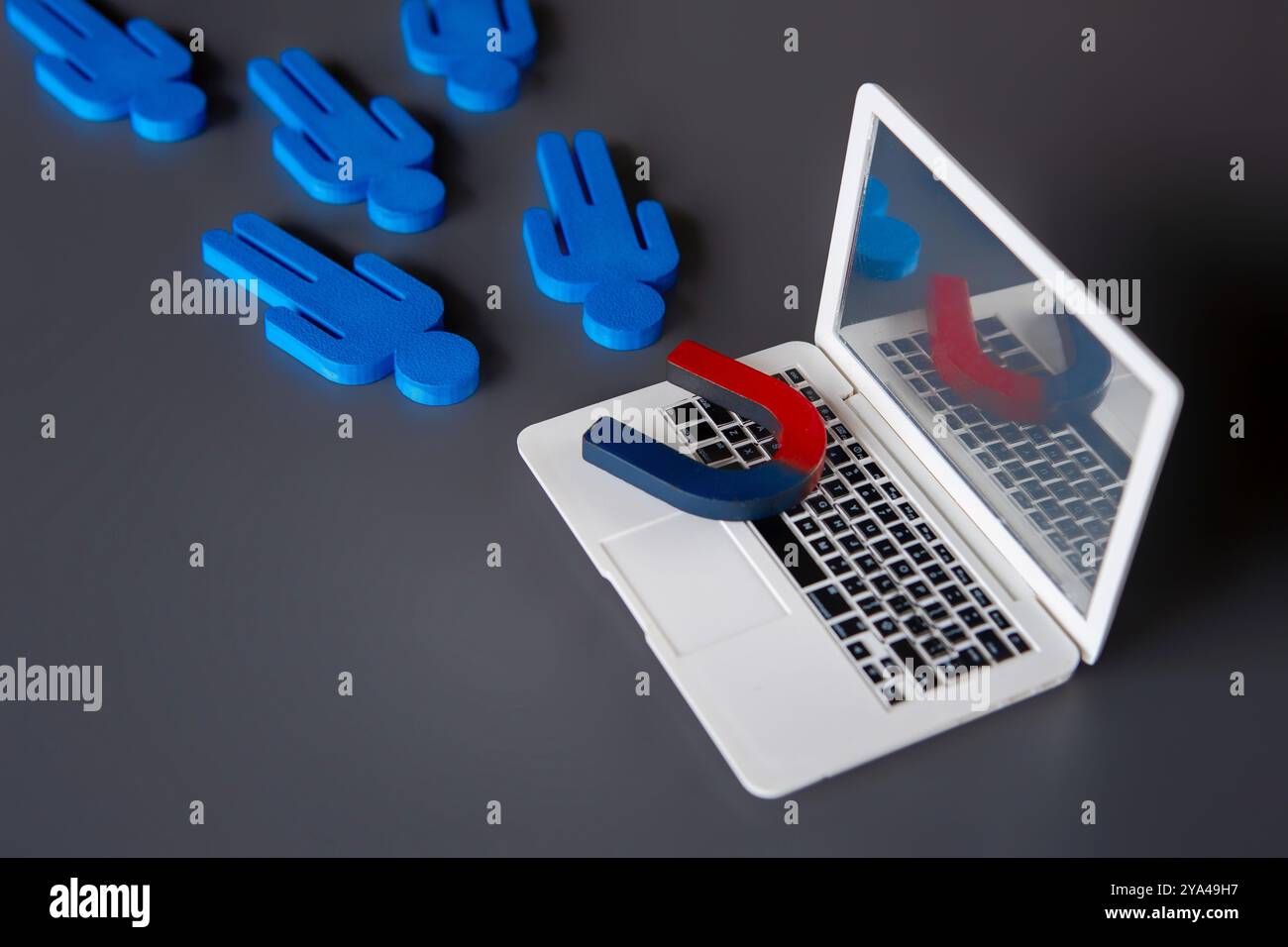 Magnet on top of a laptop attract customers. Online marketing and attracting customers concept. Stock Photo