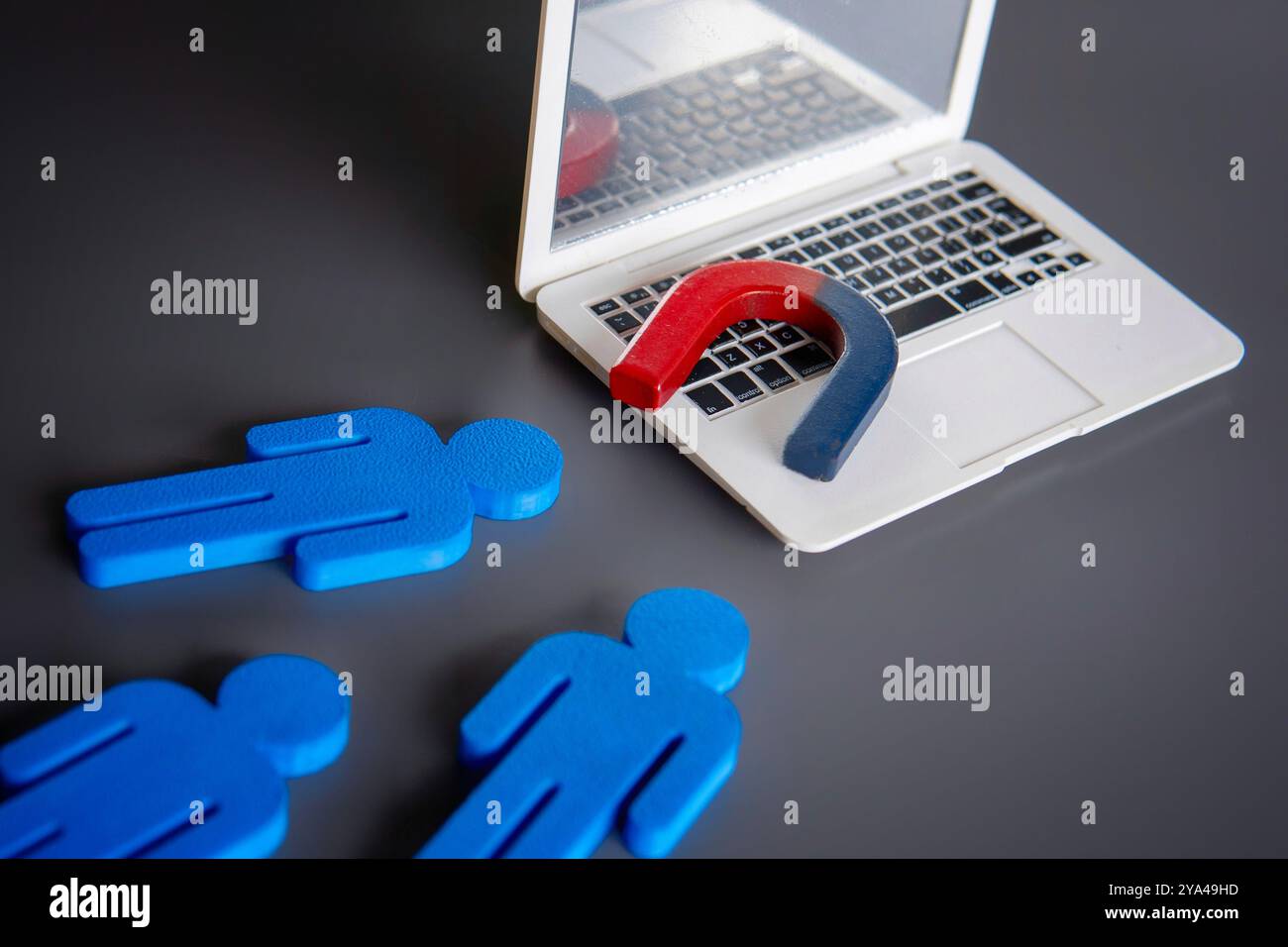 Magnet on top of a laptop attract customers. Online marketing and attracting customers concept. Stock Photo
