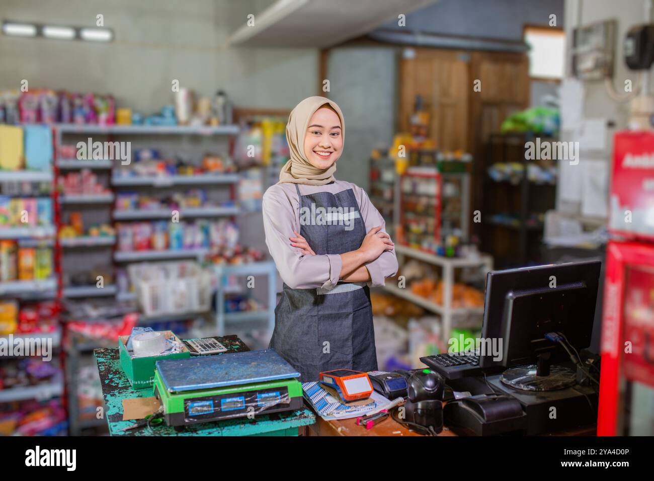 Shopkeeper Real A smiling female shopkeeper stands proudly in her organized grocery ...