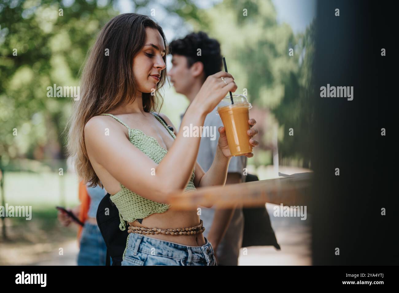 Friends buying refreshing drinks from a park drink truck on a sunny day ...