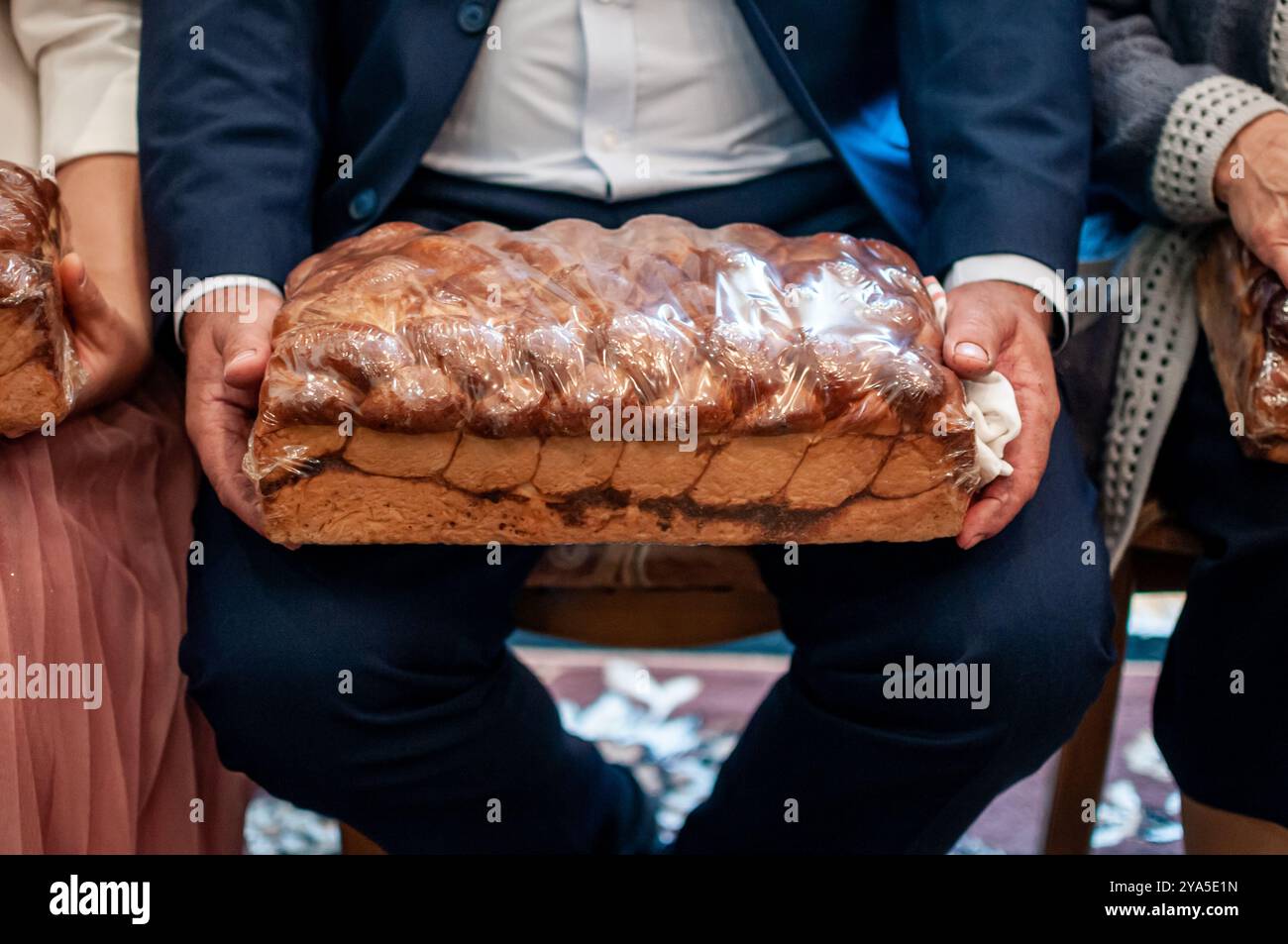 Rustic Celebration with Wrapped Bread Loaf in Hands of Guests Stock ...