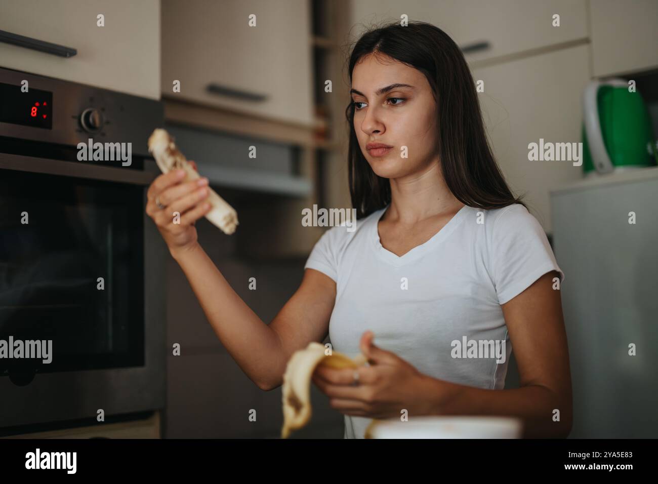 Young woman peeling banana standing hi-res stock photography and images ...