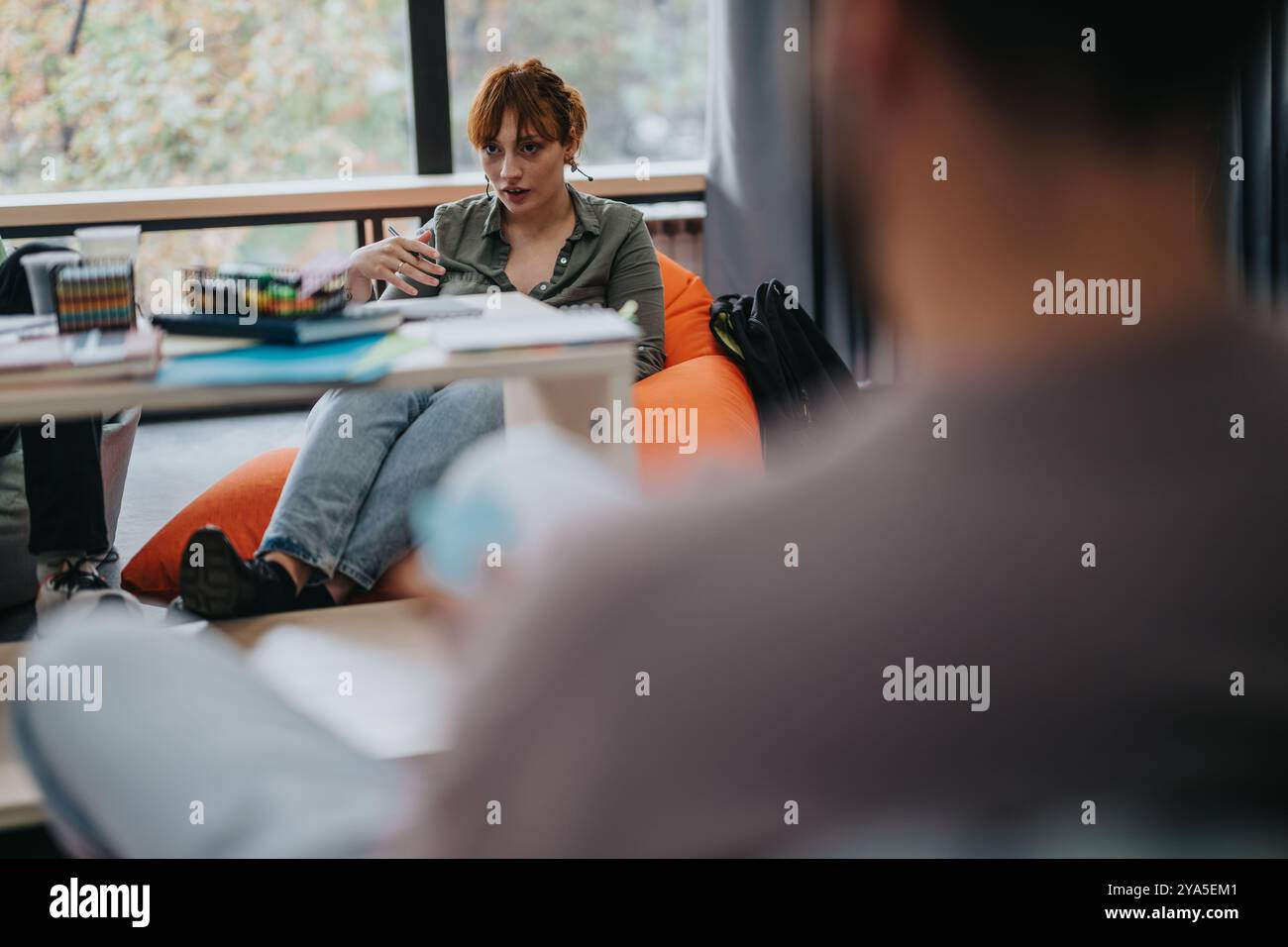 Professor engaging with students in a relaxed classroom setting Stock Photo