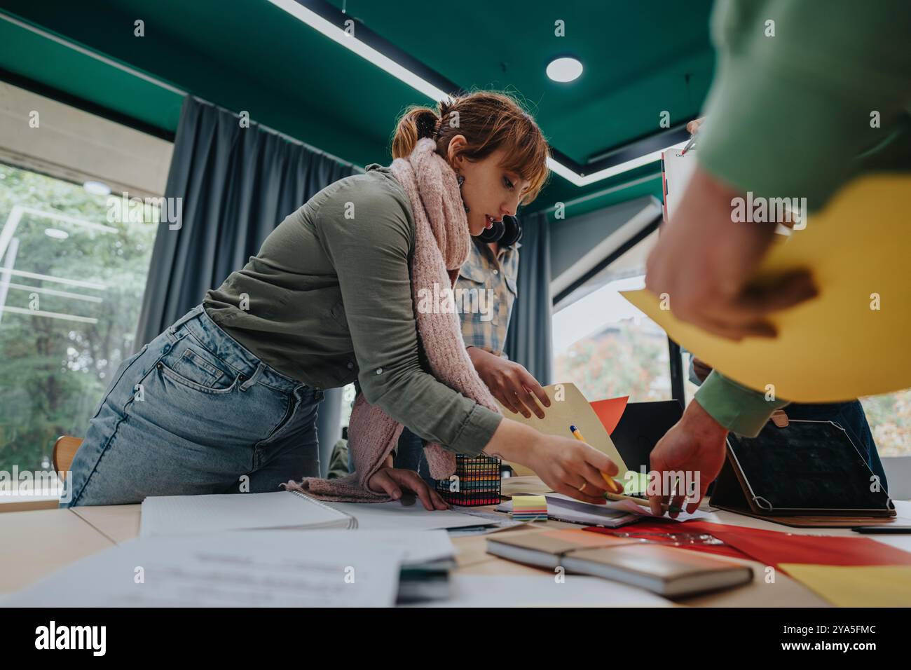Students collaborating on creative projects in a bright classroom setting Stock Photo