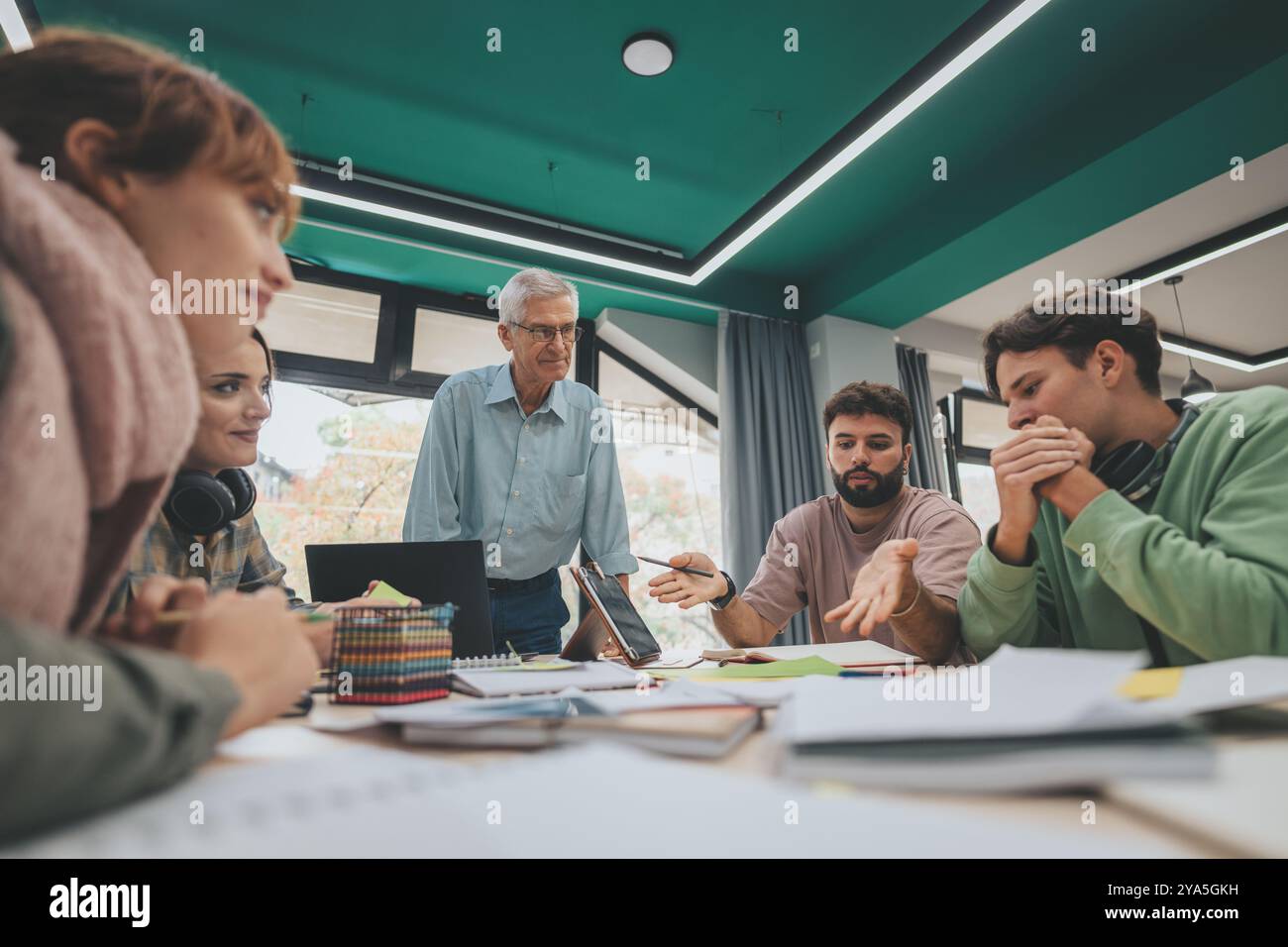 University students collaborating on a project with experienced professor Stock Photo