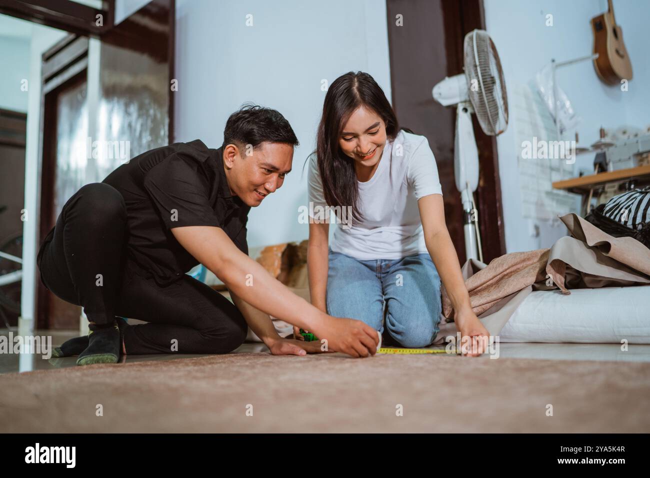 couple of asian production crew measuring the fabric using the measurement tape Stock Photo