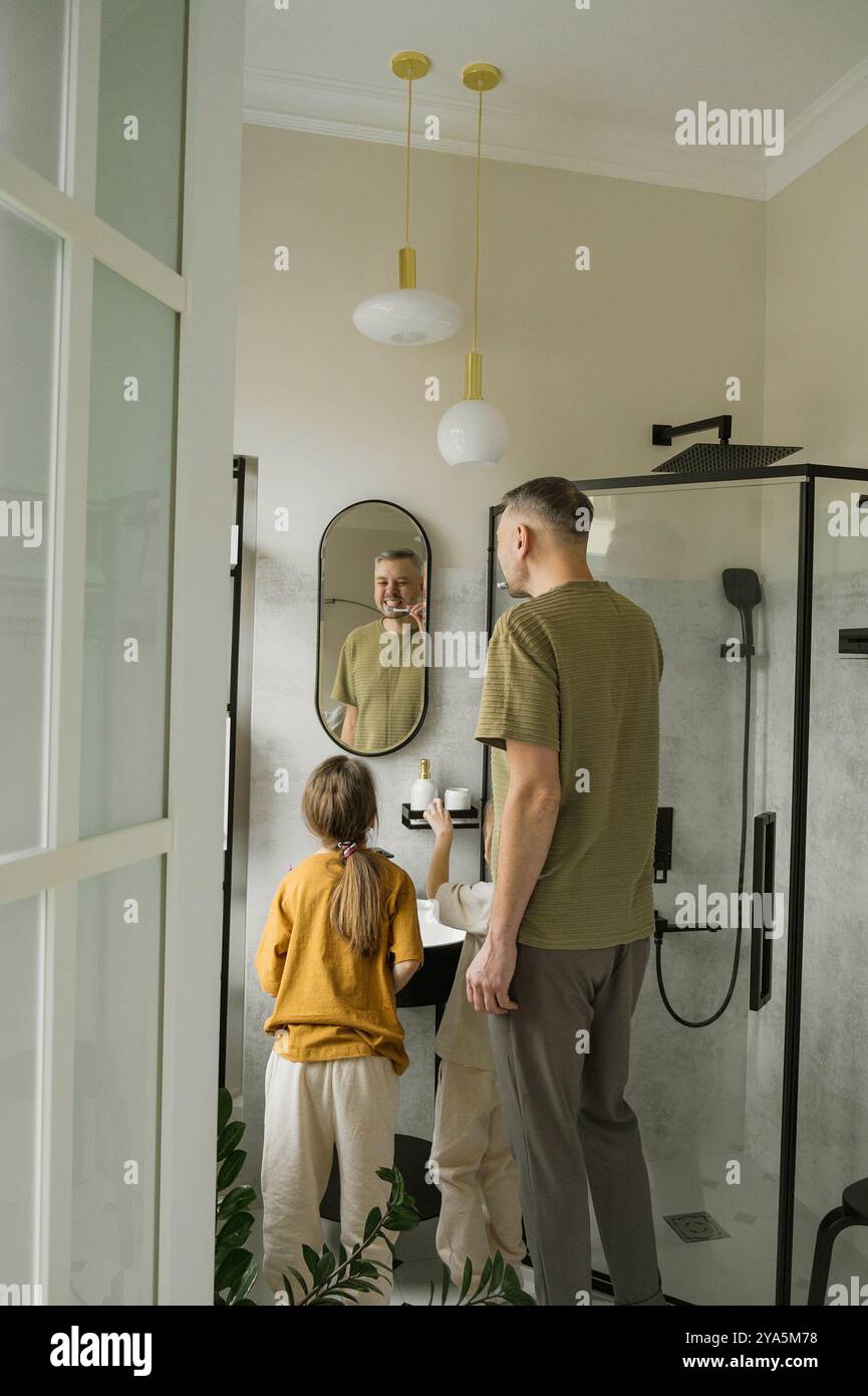 A Father Demonstrates Proper Tooth Brushing Technique To His Two Young A father demonstrates proper tooth brushing technique to his two young