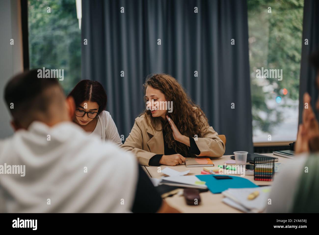 Students collaborating in a lively study group session at school Stock Photo