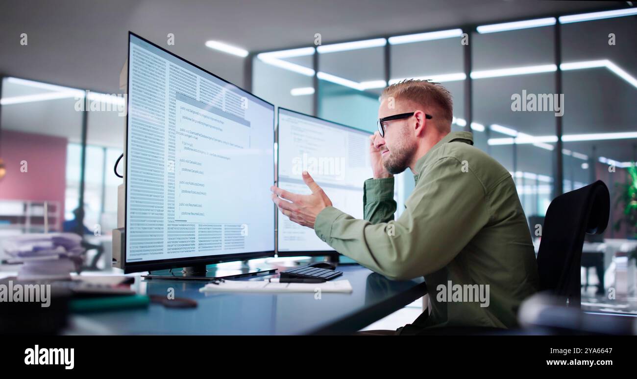 Unhappy Sad Developer Programmer Man In Stress Coding Software On Computer Stock Photo