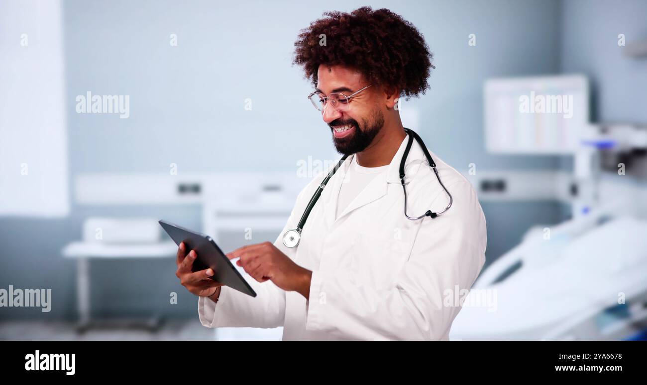 Happy African American Man Doctor In Hospital Using Tablet Computer Stock Photo