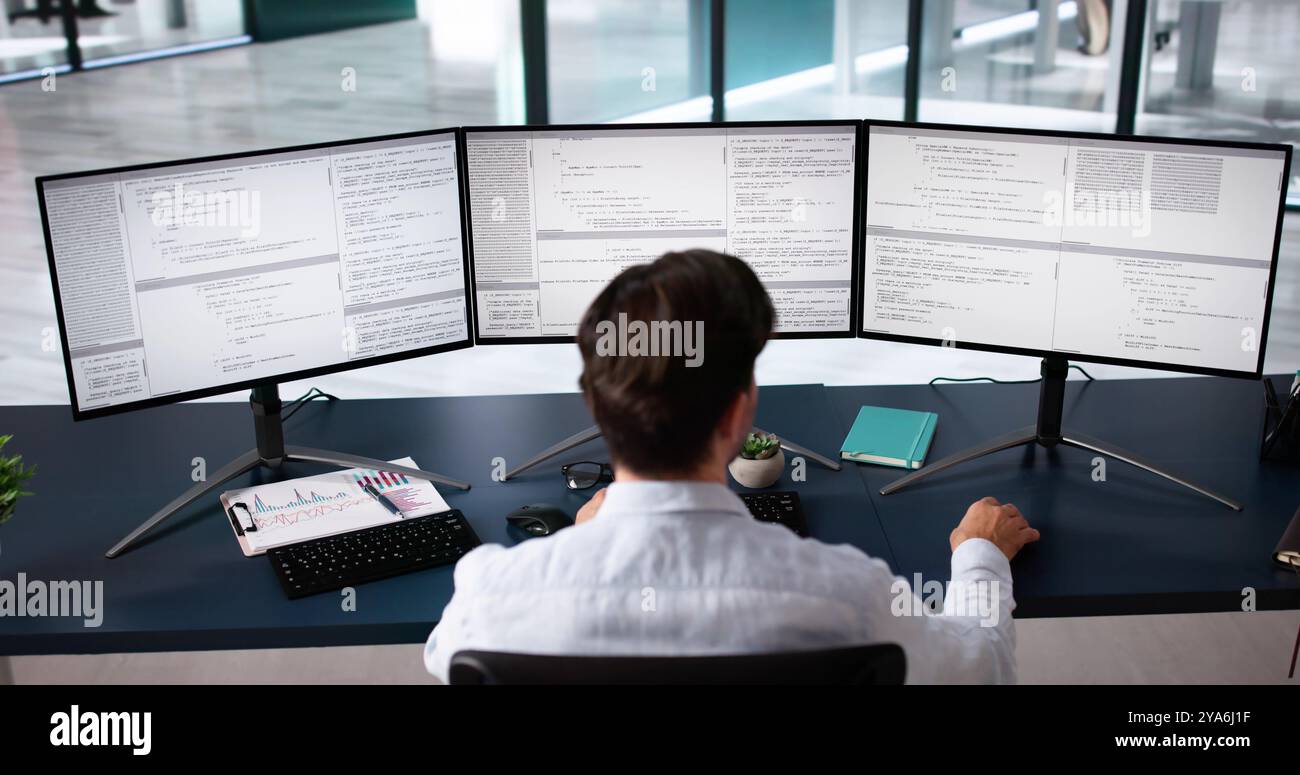 Coder Using Computer At Desk. Web Developer Stock Photo